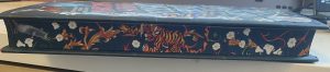 An edge view of a book showing a tiger and various plants sprayed on the edges of the pages