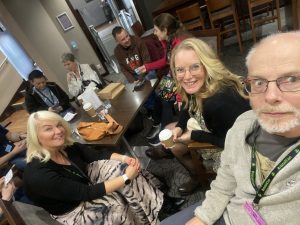 A selfie capturing people sitting in a bar with drinks